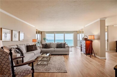 Living room with crown molding, light hardwood / wood-style flooring, floor to ceiling windows, and a view of the Gulf of Mexico
