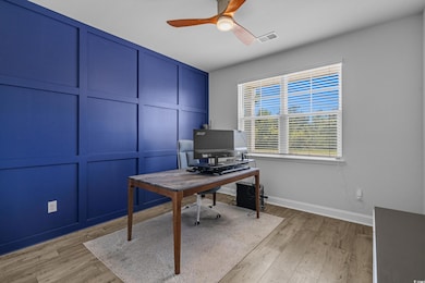 Office with ceiling fan, baseboards, and light wood-style flooring