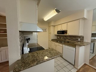 This kitchen features granite countertops, white c