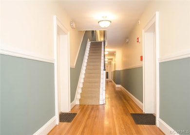 The lobby corridor has a fresh coat of paint, and is brightly lit. Unit #9 is just up the stairs on the left.