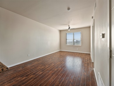 Unfurnished living room with dark wood-type flooring and a ceiling fan