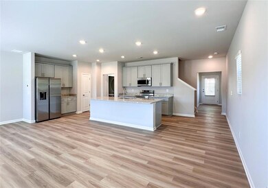 Kitchen featuring appliances with stainless steel finishes, gray cabinetry, baseboards, light wood finished floors, and recessed lighting