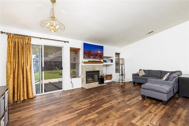 Spacious family room with new luxury vinyl plank flooring.  Fire place. Sliding door out to covered patio.