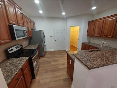 Kitchen with stainless steel appliances, a sink, d