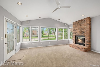 Unfurnished living room with carpet flooring, a fireplace, vaulted ceiling, ceiling fan, and recessed lighting