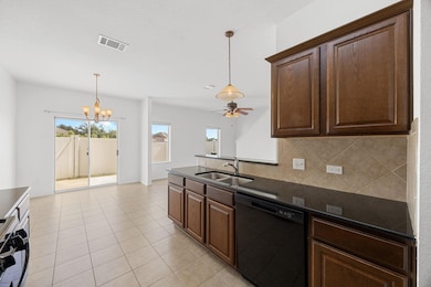 Kitchen with a peninsula, black dishwasher, hanging light fixtures, stainless steel range with gas cooktop, and tasteful backsplash
