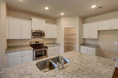  Open kitchen with granite island.  All photos are of a similar property, not the listed property.