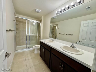Full bathroom featuring tile patterned floors, visible vents, a sink, and a stall shower