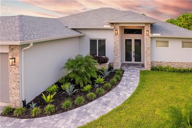 Exterior entry at dusk with french doors and a yar