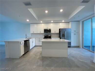 Kitchen with white cabinets, a raised ceiling, a k