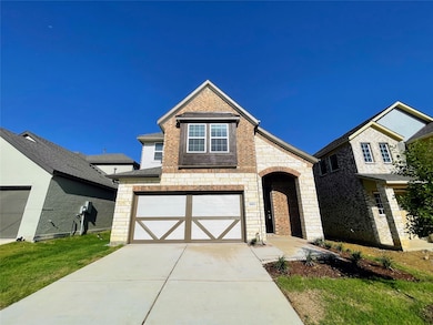 View of front of house featuring stone siding, driveway, a garage, and brick siding