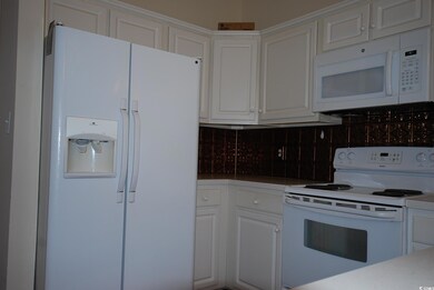 Kitchen featuring decorative backsplash, white cab