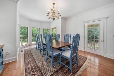 Dining area with a chandelier, plenty of natural light, light wood finished floors, and crown molding