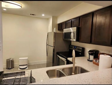 Kitchen featuring a sink, light stone counters, vi