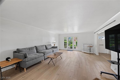 Living area featuring crown molding, french doors,
