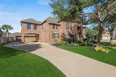 Beautiful 2-story home with lush landscaping and mature trees.