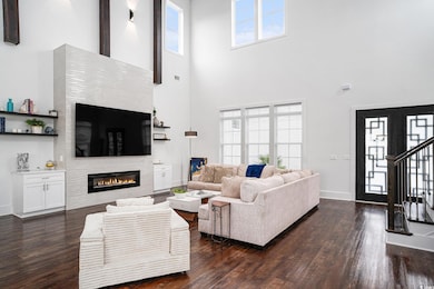 Living room featuring a towering ceiling, dark woo