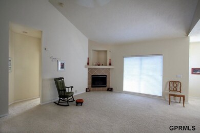 Open floor plan with cathedral ceiling and neutral colors.