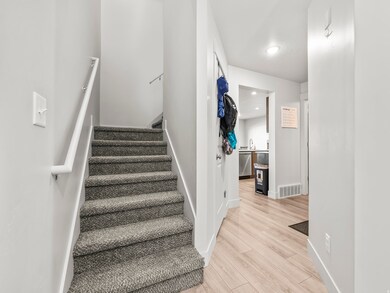 Staircase with wood finished floors and recessed lighting