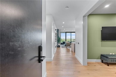 Hall with light wood-style flooring, recessed lighting, and a wall of windows