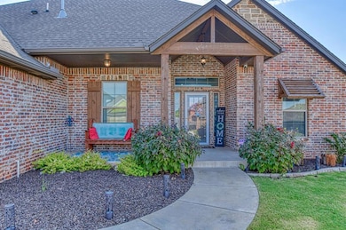 Doorway to property with a yard, a shingled roof, brick siding, and covered porch