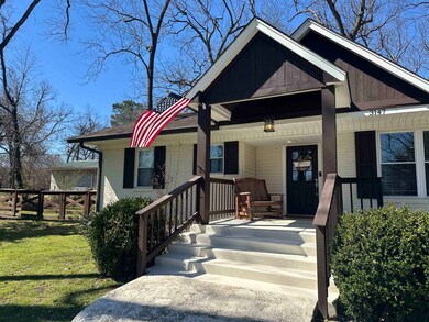 Bungalow-style home featuring brick siding, covere