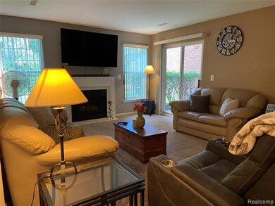 Carpeted living area with a fireplace and baseboards
