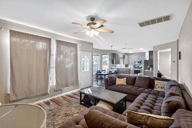 Living area with wood finished floors and a ceiling fan