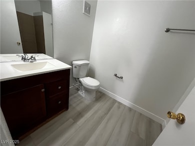 Bathroom featuring toilet, wood finished floors, v