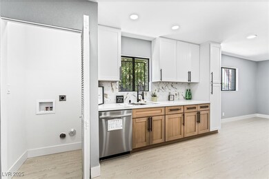 Kitchen with stainless steel dishwasher, light cou