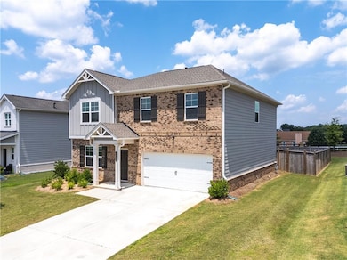 Craftsman inspired home featuring a garage, board and batten siding, concrete driveway, and brick siding