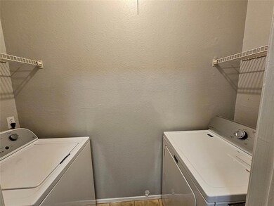 Washroom featuring a textured wall and separate washer and dryer