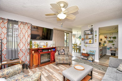 Living room with a textured ceiling and a ceiling fan