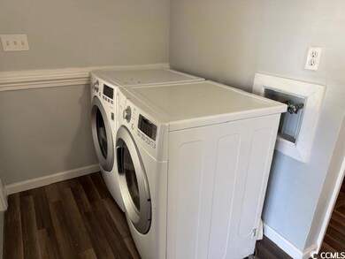 Laundry area with washer and dryer and dark hardwo