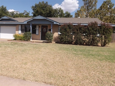 Ranch-style house with a porch, a front yard, and brick siding