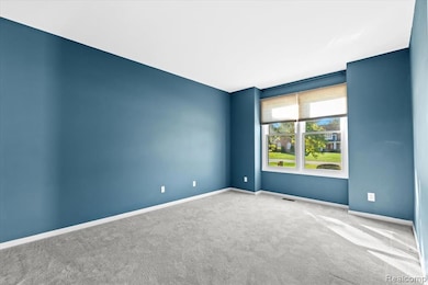 Carpeted empty room with baseboards