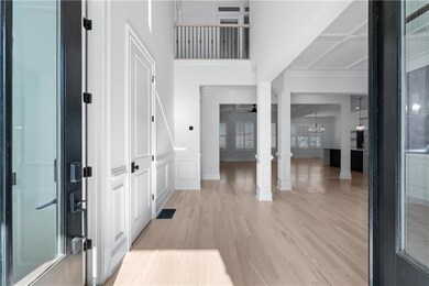 Foyer entrance featuring a chandelier, light wood-type flooring, baseboards, and a ceiling fan