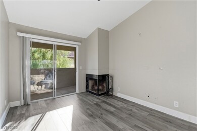 Unfurnished living room featuring vaulted ceiling, light wood-type flooring, and a fireplace