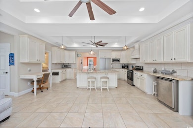 Kitchen with tasteful backsplash, a raised ceiling