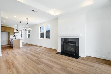 Unfurnished living room featuring light wood finished floors, a glass covered fireplace, recessed lighting, a chandelier, and baseboards