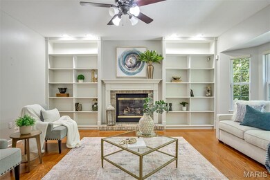 Living area with wood finished floors, built-ins, and a fireplace