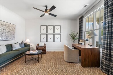 Office area featuring visible vents, baseboards, ornamental molding, and a ceiling fan