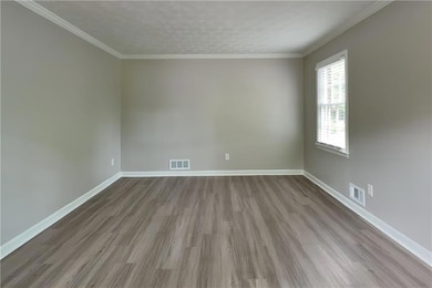 Unfurnished room featuring wood finished floors and crown molding