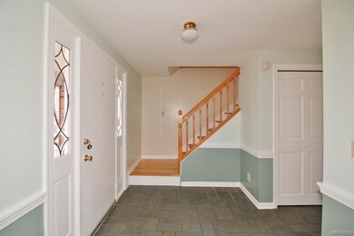 Freshly-painted foyer with slate floor and closet 