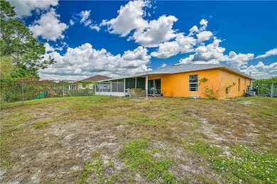 Back of property featuring a fenced backyard, a playground, stucco siding, and a sunroom