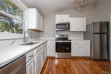 Kitchen featuring light countertops, appliances wi
