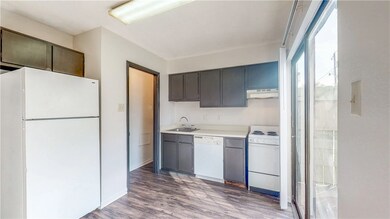 Kitchen featuring white appliances, sink, and hard