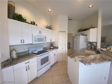 Kitchen with white cabinetry, light tile patterned