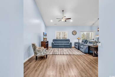 Living room featuring baseboards, ceiling fan, and