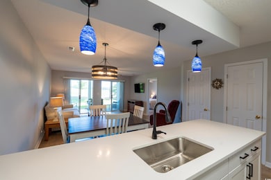 Kitchen with decorative light fixtures, a sink, ba
